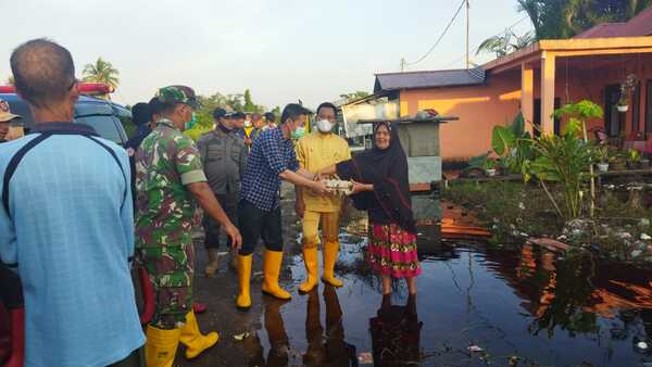 Bupati dan Wakil Bupati Rohil menyerahkan Sembako kepada warga terdampak banjir. 